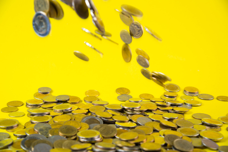 Falling coins money on yellow background, business wealth concept idea.の写真素材