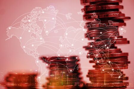 Double exposure of coin stack with city background and world map, financial graph, world map and global network business concept idea.の写真素材
