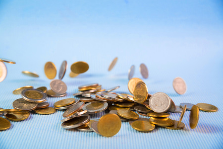 Falling coins money on blue background, business wealth concept idea.