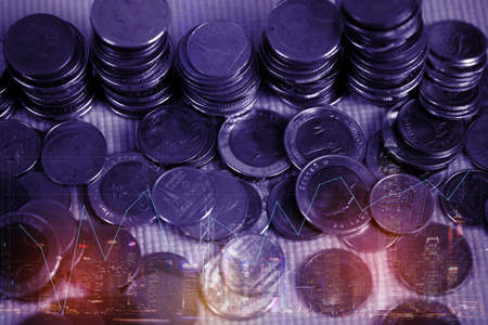 Double exposure of coin stack with city background and world map, financial graph, business concept idea.の写真素材