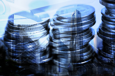 Double exposure Stack of coin with financial graph over city and office building background,...