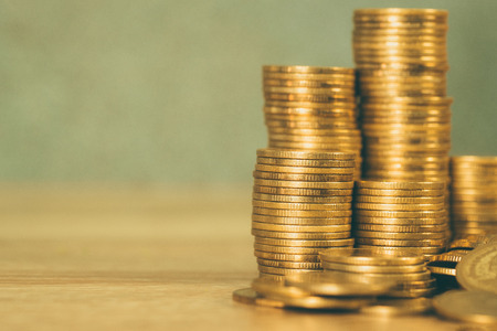 Columns of gold coins, piles of coins on working table, business banking and financial concept idea.の写真素材