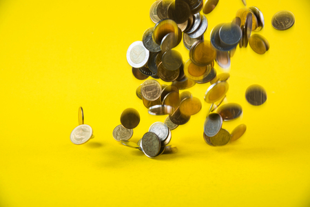 Falling coins money on yellow background, business wealth concept idea.の写真素材