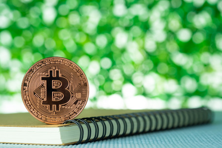 Bitcoin digital currency,  bit-coin on green blurred bokeh background, Cryptocurrency money concept idea.の写真素材