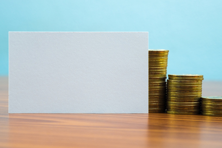 Blank business card or name card with space for add text name address and logo, stack of coin on working table, financial company concept idea.の写真素材