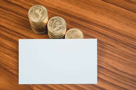 Blank business card or name card with space for add text name address and logo, stack of coin on working table, financial company concept idea.の写真素材
