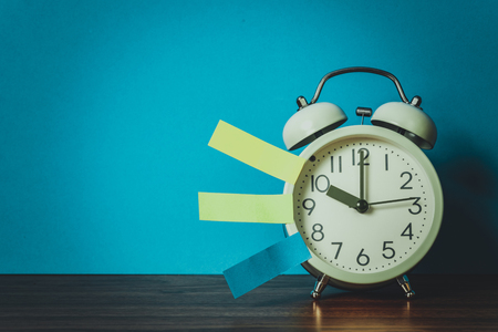 Note paper sticky and vintage alarm clock on table with copy space for add text notice something, list memo and schedule concept idea.の写真素材