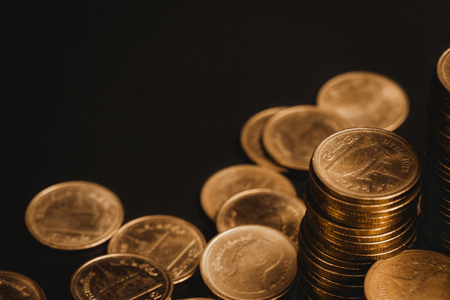 Savings, increasing columns of coins, piles of coins arranged as a graph in dark room, business banking concept ideaの写真素材
