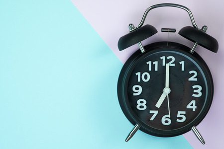 Flat lay vintage alarm clock on sweet pastel colored paper top view, background texture, pink,...