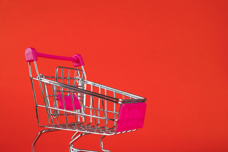 Shopping cart or supermarket trolley on red background, business finance shopping concept idea.の写真素材