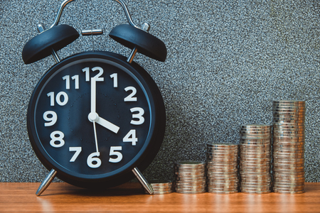 Alarm clock and step of coins stacks on working table, time for savings money concept, banking and...