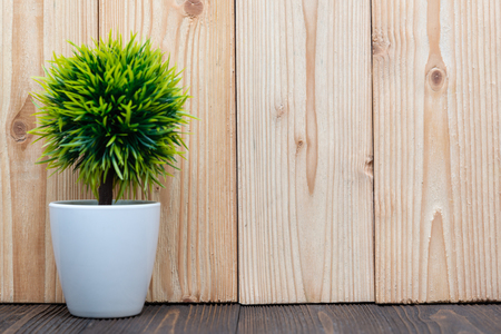 Little decorative tree and flower bouquet in white vase on wooden table with copy space. background.の写真素材