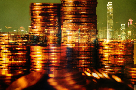 Double exposure Stack of coin with financial graph over city and office building background, business and financial concept idea.の写真素材