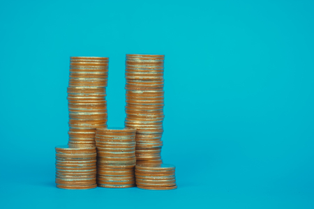 Columns of coins, piles of coins on blue background, business and financial concept idea.