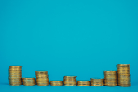 Columns of coins, piles of coins on blue background, business and financial concept idea.
