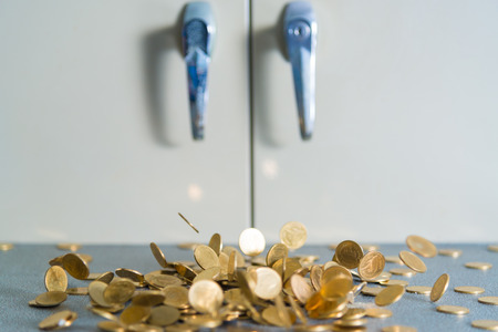 Falling gold coins money on office table with document cabinet background, business money and finance concept idea.の写真素材