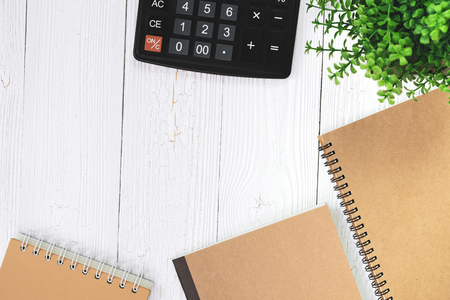 Fountain pen or ink pen with notebook paper and calculator on wooden working table with copy space, office desk concept idea. top view.の写真素材