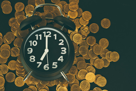 Alarm clock and coins stacks on working table, time for savings money concept, banking and business...