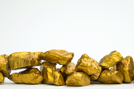 A pile of gold nuggets or gold ore isolated on white background, precious stone or lump of golden stone, financial and business concept idea.の写真素材