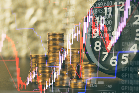 Double exposure of alarm clock and coins stacks with candle stick and stock market price screen, time for savings money concept, banking and business concept idea.の写真素材