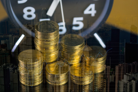 Coins stacks and alarm clock in dark room, business and finance concept idea.
