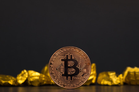 Closeup of bitcoin digital currency and gold nugget or gold ore on black background, precious stone or lump of golden stone, Cryptocurrency money financial and business concept idea.の写真素材