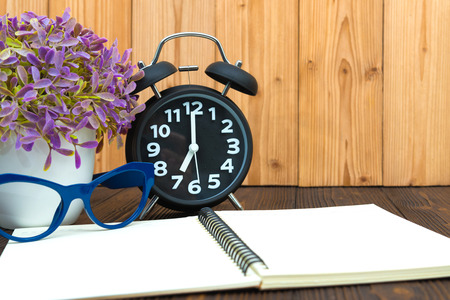 Office supplies or office work essential tools items, notebook and alarm clock with little tree and...