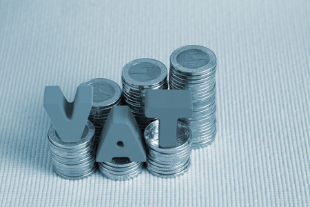 VAT (Value Added Tax) concept. Word VAT alphabet made from wood with stack of coin, business and financial concept idea.の写真素材