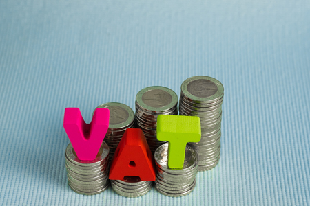 VAT (Value Added Tax) concept. Word VAT alphabet made from wood with stack of coin, business and financial concept idea.の写真素材