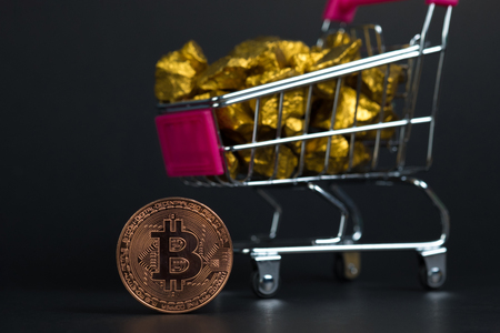 Closeup of bitcoin digital currency and gold nugget or gold ore in trolley, precious stone or lump of golden stone, Cryptocurrency money financial and business concept idea.の写真素材