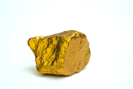 Closeup of gold nugget or gold ore on white background, precious stone or lump of golden stone, financial and business concept idea.の写真素材