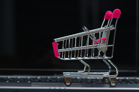 Shopping cart or supermarket trolley with laptop notebook and copy space, e-commerce and online shopping concept.の写真素材