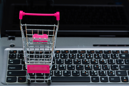 Shopping cart or supermarket trolley with laptop notebook and copy space, e-commerce and online shopping concept.の写真素材
