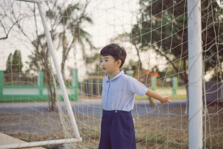 Outdoor portrait of a happy Asian student kid in school uniform smiling with copy space for add text...
