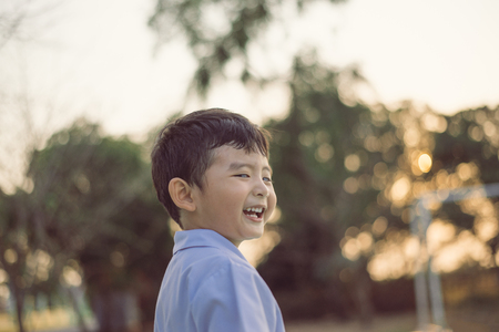 Outdoor portrait of a happy Asian student kid in school uniform smiling with copy space for add text or word.の写真素材