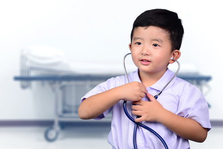 Asian Thai kid with medical stethoscope looking at camera, healthy concept idea.の写真素材