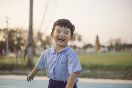 Outdoor portrait of a happy Asian student kid in school uniform smiling with copy space for add text or word.の写真素材