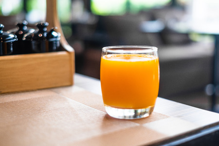 Glass of orange juice on table in restaurant for breakfast in the morning.
