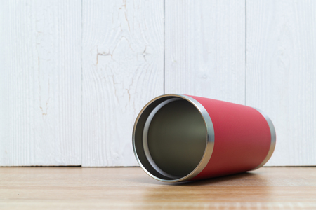 Red colour stainless steel tumbler or cold and hot storage cup on wooden background.の写真素材