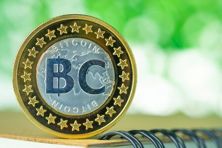 Bitcoin digital currency,  bit-coin on green blurred bokeh background, Cryptocurrency money concept idea.の写真素材