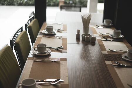 Empty restaurant part of hotel resort with table and armchair near windows.の写真素材