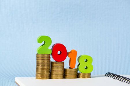 2018 wooden text and step of coins stack on notebook paper with copy space for add text, financial and business planning on year 2018 concept. idea.の写真素材