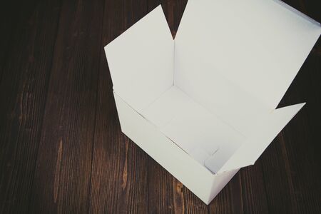 Empty white gift box or tray for mock up on dark wooden table with copy space.の写真素材