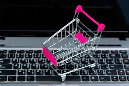 Shopping cart or supermarket trolley with laptop notebook and copy space, e-commerce and online shopping concept.の写真素材