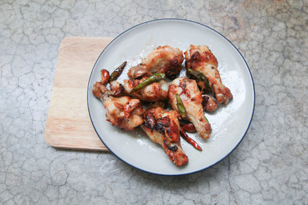 fried chicken with garlic and chilli in dish on concrete backgroundの写真素材