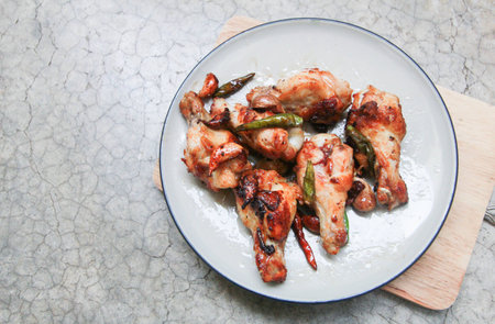 fried chicken with garlic and chilli in dish on concrete backgroundの写真素材