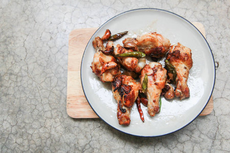 fried chicken with garlic and chilli in dish on concrete backgroundの写真素材