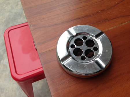 Old ashtray made of galvanize on Wooden deskの写真素材