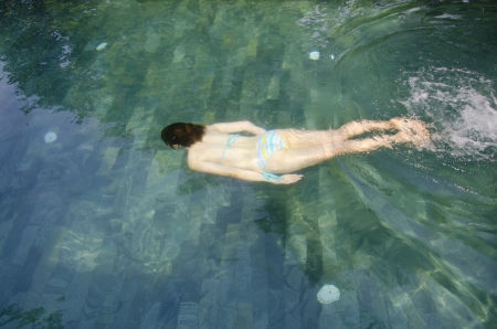 young asian girl is swimming in the poolの写真素材