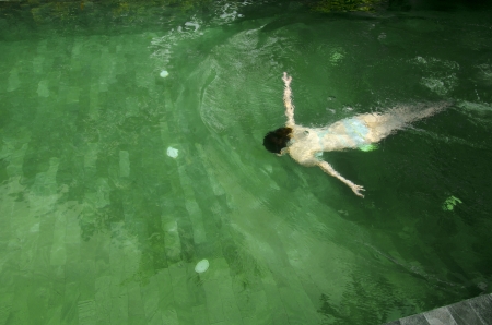 young asian girl is swimming in the poolの写真素材